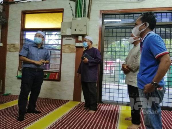 Noor Azmi (kiri) ketika meninjau keadaan Masjid Jamek 2, Kuala Kurau hari ini.