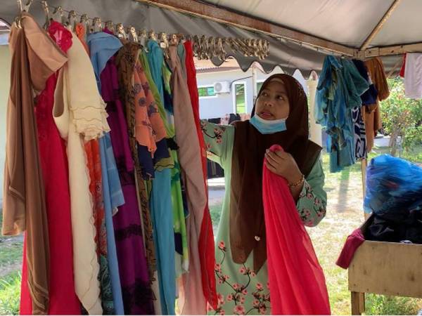 Norizan menggantung tudung yang didermakan orang ramai.