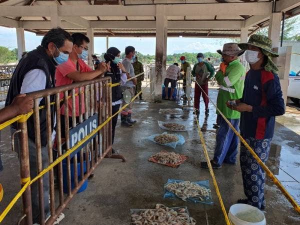 Wazir (kiri) ketika meninjau urusan jual beli yang dilakukan di Pasar Bisik.