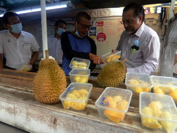 Exco Perumahan, Kerajaan Tempatan dan Perancang Bandar dan Desa Jagdeep Singh Deo (kanan) melihat durian yang diisi di dalam bekas yang ditunjuk oleh pemiliki kedai durian Ah Teik (dua, kanan) semasa melakukan pemantaun di gerai durian sepanjang Lorong Susu agar mematuhi Prosedur Operasi Standard (SOP) yang ditetapkan hari ini.
Peniaga durian di tepi jalan boleh beroperasi mulai hari ini dengan syarat pelanggan tidak dibenarkan makan di situ dan isi durian diletakkan di dalam bekas.-fotoBERNAMA