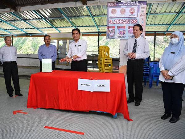 Dr Mohd Radzi Md Jidin (tengah) memberi penerangan berkenaan pembelian makanan pelajar mengikut garis panduan ketika melakukan lawatan kerja di Sekolah Menengah Kebangsaan (SMK) Engku Husain, Kajang. - Foto Bernama