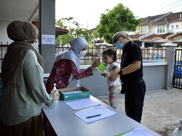 Pengurus Taska Permata DD, Nor Asmah Md Nor (dua, kiri) mengambil suhu badan pada kanak-kanak Maryam Orked Azween Azizuddin (dua, kanan) ketika hadir di Taska Permata DD hari ini.