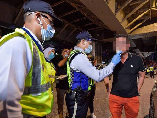 Anggota Polis melakukan ujian pengesanan alkohol dalam badan terhadap seorang pemandu menggunakan alat pengesan kandungan alkohol dalam sekatan jalan raya yang dilaksanakan bagi mengesan pemandu mabuk di Jalan Hang Tuah malam tadi.