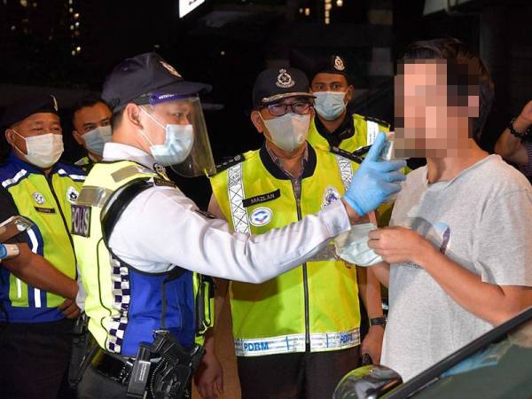 Ketua Polis Kuala Lumpur Datuk Seri Mazlan Lazim (tengah) memantau salah seorang anggotanya yang sedang melakukan ujian pengesanan alkohol dalam badan terhadap seorang pemandu menggunakan alat pengesan kandungan alkohol dalam sekatan jalan raya yang dilaksanakan bagi mengesan pemandu mabuk di Jalan Hang Tuah malam ini.