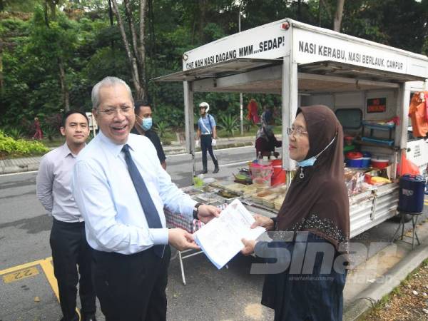 Annuar menyerahkan lesen niaga kepada Cik Nah hari ini.