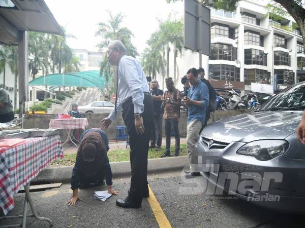 Cik Nah melakukan sujud syukur sebaik menerima lesen niaga disampaikan sendiri oleh Annuar, di Jalan Setia Bakti di sini hari ini.