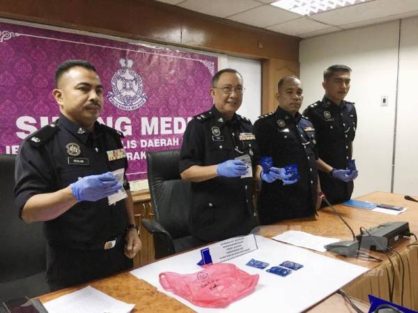 Omar Bakhtiar (dua dari kiri) menunjukkan pil kuda yang dirampas daripada seorang lelaki di R&R Gunung Semanggol.