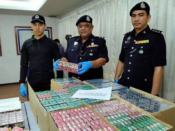 Mohd Yusuf (tengah) menunjukkan rokok yang dipercayai diseludup.