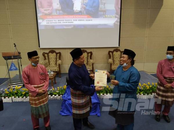 Mazlan menyampaikan Anugerah Ikon Guru Teknologi Maklumat dan Komunikasi kepada guru Sekolah Menengah Kebangsaan ( SMK) Mutiara Rini, Mohd Fadzil Abdul Hamid di Jabatan Pendidikan Negeri Johor hari ini.