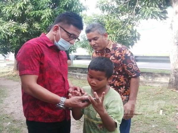 Norhizam menunjukkan Noridzuan video yang tular selepas kanak-kanak itu bertemu dengannya. 