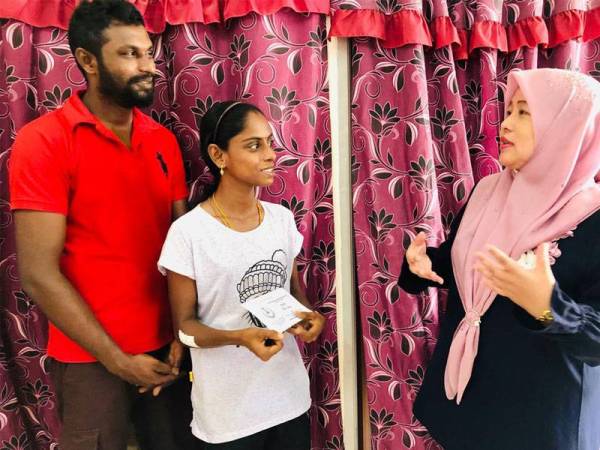 Wan Norashikin menyampaikan sumbangan kepada Pavithra.