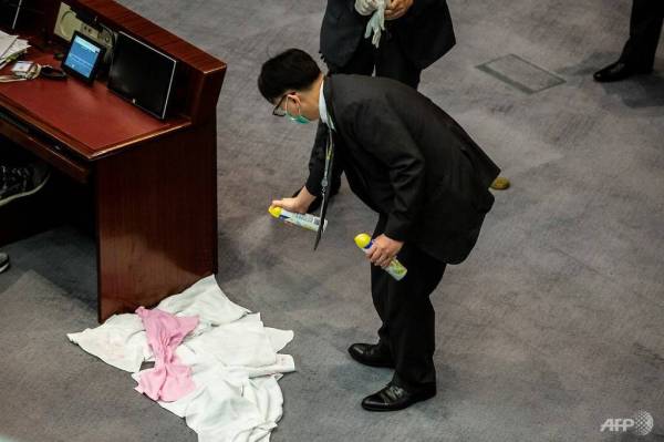 Seorang pengawal keselamatan membersihkan bangkai sotong yang dilemparkan oleh seorang ahli majlis perundangan di Hong Kong. -Foto AFP
