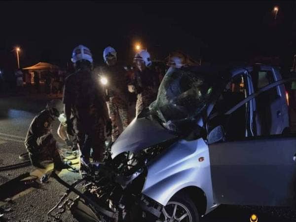 Anggota bomba dari Balai Gebeng membantu mengeluarkan pemandu kereta yang tersepit selepas terbabit kemalangan dengan sebuah lori di Kilometer 31, Jalan Kuantan-Kemaman, awal pagi tadi. - Foto JBPM