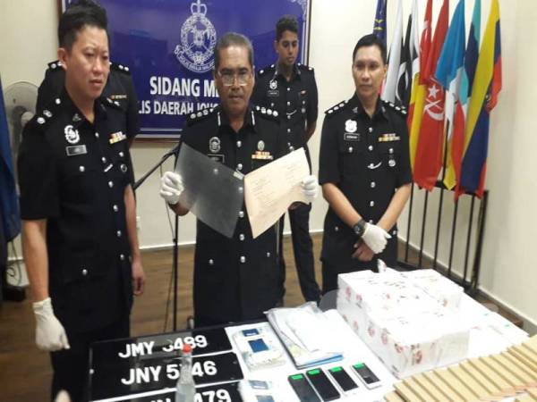 Mohd Padzli (tengah) dan Timbalannya, Superintendan Lim Jit Huey (kiri) menunjukkan salinan surat MC palsu yang dijual sindiket kepada pekerja sekitar Johor Bahru dan negara jiran pada sidang akhbar di IPD Johor Bahru Selatan, Larkin, Johor Bahru hari ini.