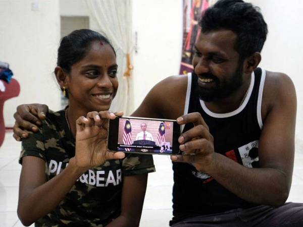 S.Pavithra,28, (kiri) bersama suaminya M.Sugu,29 teruja selepas melihat video Perdana Menteri yang menyebut nama mereka semasa mengumumkan Pelan Jana Semula Ekonomi Negara (Penjana) yang disiarkan secara langsung di seluruh negara hari ini. Foto: Bernama