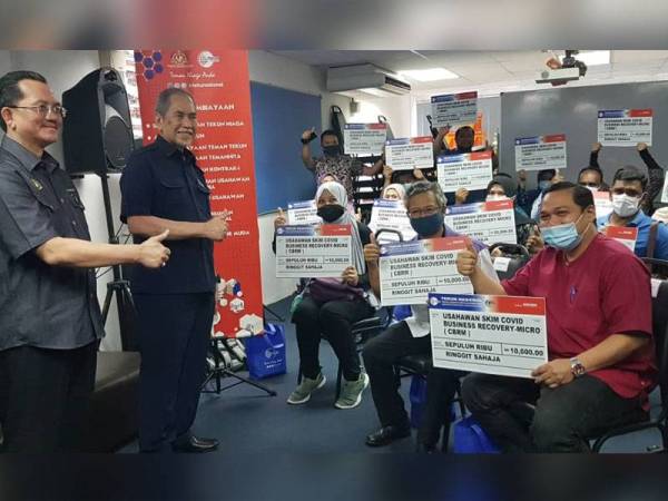 Wan Junaidi (dua dari kiri) bermesra bersama 21 usahawan mikro yang menerima pembiayaan Skim CBRM pada majlis penyampaian di Pejabat Tekun Nasional Selangor di Shah Alam hari ini.
