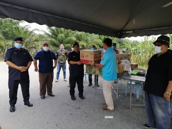 Wakil Umno cawangan Sepang dan Kuala Langat menyampaikan sumbangan kepada petugas keselamatan yang diterima oleh Azizan.