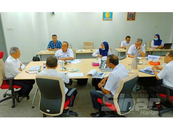 Mustapa (kiri) ketika mendengar taklimat semasa lawatan beliau ke ECER Rantau Panjang.