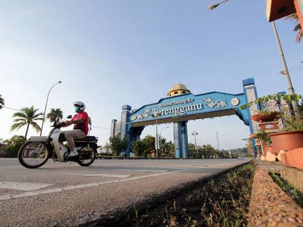 Seorang penunggang motosikal melalui pintu gerbang sempadan negeri Pahang dan Terengganu di Kampung Chendor hari ini.