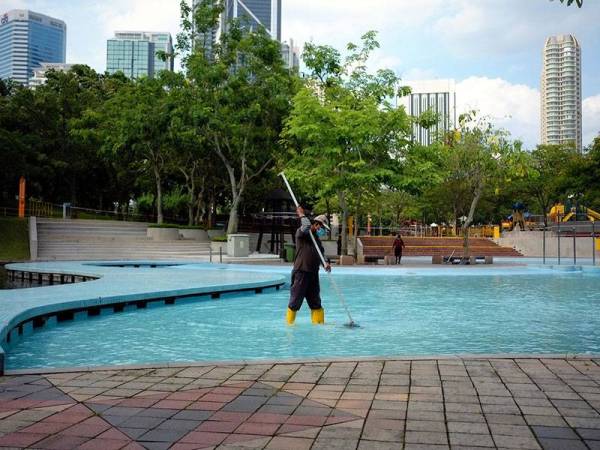 Seorang pekerja melakukan kerja pembersihan di sekitar taman rekreasi Suria KLCC ketika tinjauan hari ini.