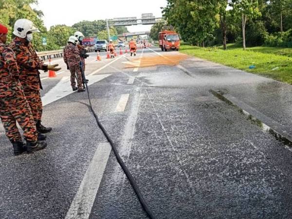 Operasi pembersihan dilakukan akibat tumpahan minyak diesel di kilometer 107.6 Lebuh Raya Utara Selatan kira-kira 4.50 petang tadi. Foto JBPM