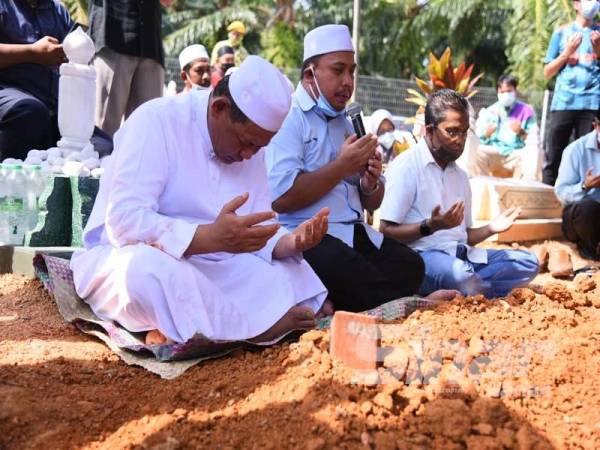 Aminuddin (kiri) menadah tangan ketika bacaan talqin.