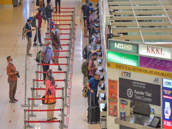 Orang ramai dilihat mematuhi penjarakkan sosial ketika membuat pembelian tiket di kaunter tiket Terminal Bersepadu Selatan (TBS). - Foto Bernama