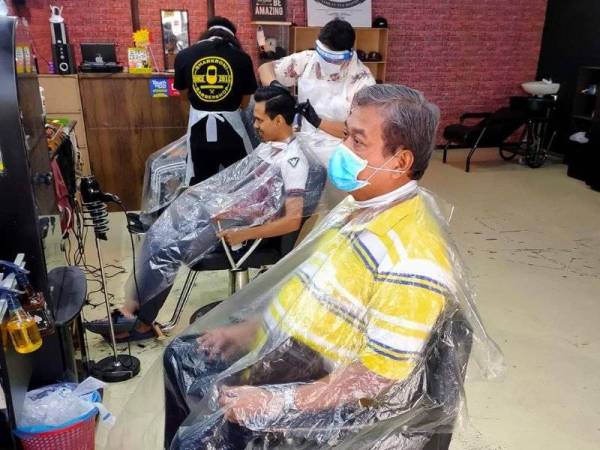 Sebahagian pelanggan Sharkroni Barbershop yang datang mendapatkan perkhidmatan guntingan sempena hari pertama kebenaran beroperasi, hari ini.