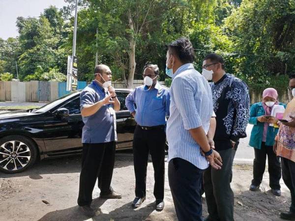 Veerapan (dua dari kiri) mendengar Penerangan daripada JAS ketika meninjau lokasi sisa buangan berbentuk cecair berwarna hitam dan berbau pelarut dikesan di tepi Jalan Tok Ungku, Rasah.