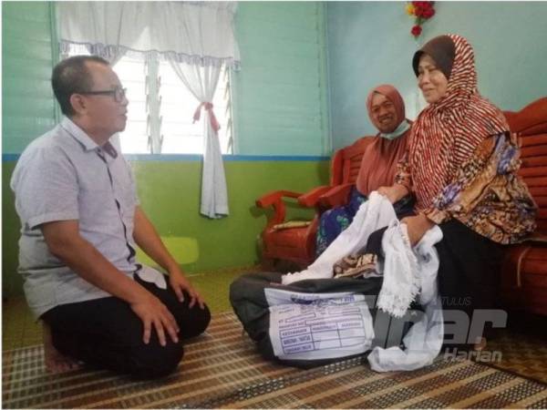 Sofi (kiri) ketika melawat Jamaliah dan Roslah susulan kerajaan menangguhkan penghantaran jemaah haji pada tahun ini di Kampung Belimbing Dalam.