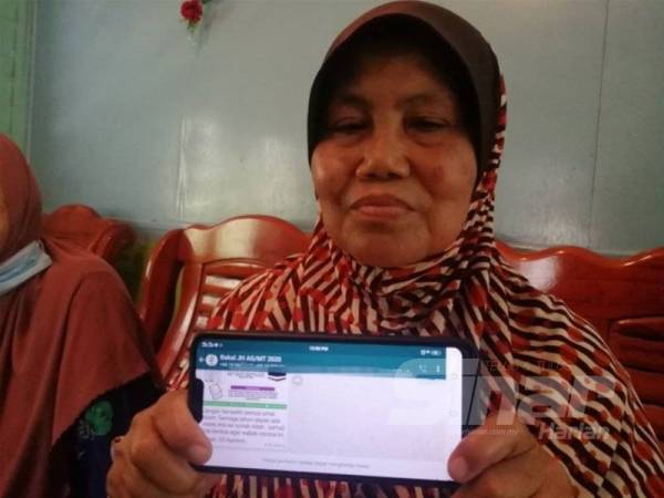 Jamaliah menunjukkan mesej yang diterima mengenai penangguhan itu dalam kumpulan WhatsApp bakal haji Alor Gajah.
