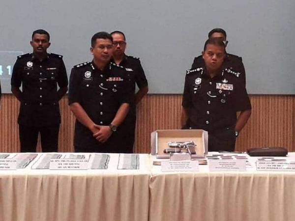 Ayob Khan (kanan) melihat barang rampasan antaranya melibatkan pelbagai jenis dadah, pistol tiruan dan wang tunai selepas menumpaskan dua sindiket, pada sidang akhbar di IPK Johor, Johor Bahru hari ini.