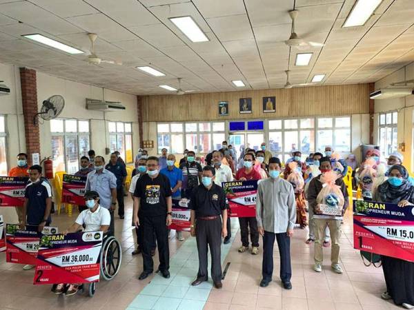 Che Abdullah bergambar bersama penerima geran dan penduduk kurang bernasib baik yang diraikan.