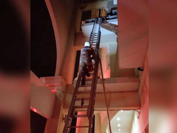 Bomba menggunakan tangga untuk membawa turun mangsa. - Foto JBPM