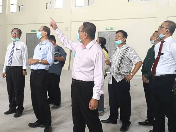 Hang Soon (dua dari kiri) diiringi Timbalan Menteri Pendidikan II, Muslimin Yahaya (dua dari kanan) melakukan lawatan di dewan SMJK Yoke Kuan yang masih dalam pembinaan di sini hari ini.