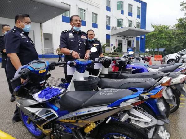 Baharudin (tengah) menunjukkan antara motosikal yang dirampas susulan tumpasnya dua geng curi motosikal, baru-baru ini.