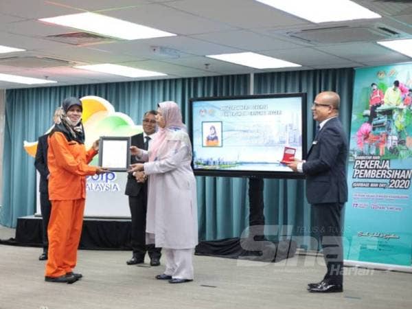 Rohani menerima Anugerah Hero Pekerja Pembersihan yang disampaikan oleh Zuraida.