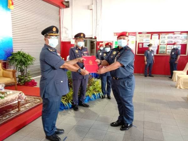 Yahya (kiri) menyampaikan Anugerah Perkhidmatan Cemerlang Zon 3 di Balai Bomba dan Penyelamat Kluang hari ini.