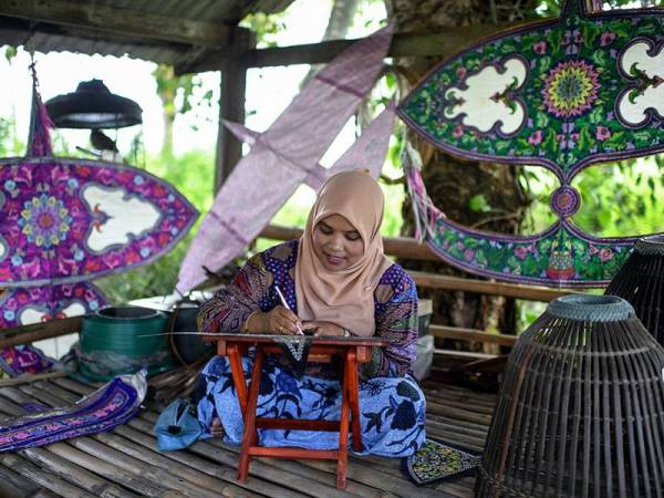 Pelayang dan pembuat wau wanita tunggal, Nor Asmah Daud, 45, sedang menyobek (mengukir) Wau Helang sebelum dilekatkan pada rangka wau selepas ditempah oleh pelanggannya di Kampung Tok Kaya, Kuala Perlis.