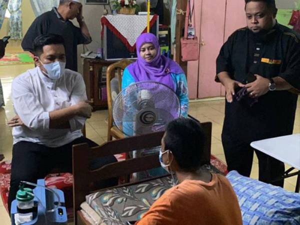 Dr Afif (kiri) menziarahi penduduk di Kampung Belah Dua sebentar tadi.