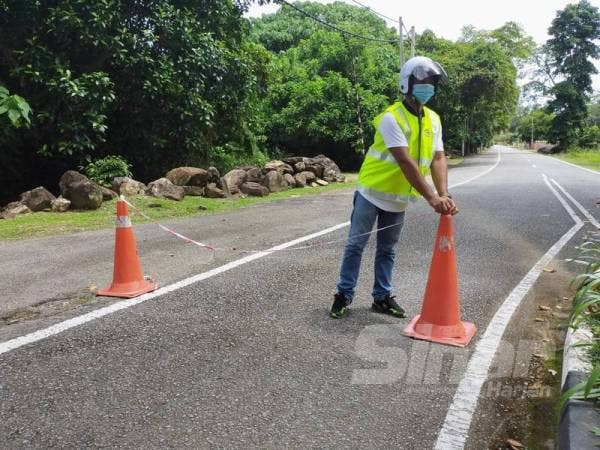 Pembantu Awam MDY, Mohamad Zamri Abu Hassan meletakkan kembali kon dan tali rentang di laluan keluar yang dialihkan pengunjung untuk masuk ke pusat peranginan berkenaan.