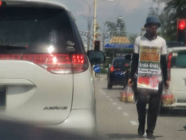 Antara penjaja di persimpangan lampu isyarat yang dilihat kembali berniaga di beberapa lokasi lampu isyarat di daerah ini sejak penguatkuasaan PKPP.