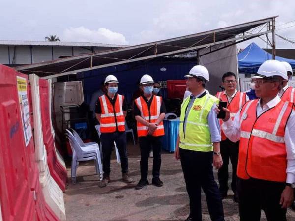 Mustapa Mohamed (tengah) melihat perkembangan Projek Landasan Berkembar Elektrik Gemas-Johor Bahru (PLBEGJB) di bandar Kulai, Johor hari ini.