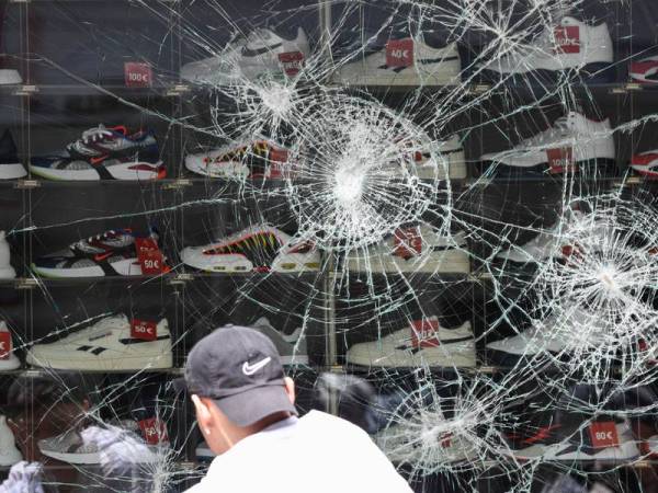 Tingkap di sebuah kedai menjual kasut menjadi sasaran amukan perusuh di Stuttgart, selatan Jerman hari ini. - FOTO: AFP