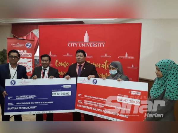 Mazlan (tengah) menerima replika cek sebelum diserahkan kepada pihak City University dalam Program Pelancaran Bantuan Pendidikan Rakyat Johor Dengam Kerjasama City University di Kompleks Yayasan Warisan Johor, Johor Bahru, hari ini.