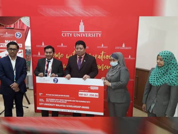 Mazlan (tengah) menerima replika cek sebelum diserahkan kepada pihak City University dalam Program Pelancaran Bantuan Pendidikan Rakyat Johor di Kompleks Yayasan Warisan Johor, Johor Bahru, hari ini.