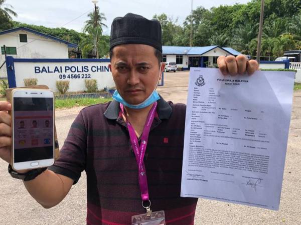 Mohd Shukri Mohd Ramli menunjukkan laporan yang dibuat di Balai Polis Chini, di sini hari ini.