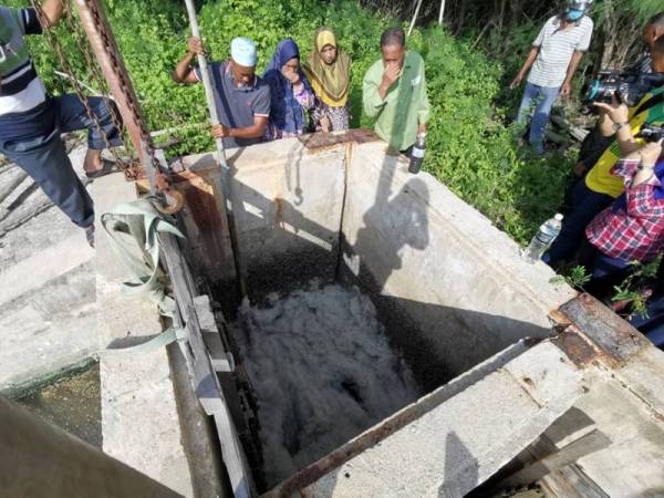 Penduduk kampung menunjukkan buih kotor yang didakwa akibat air buangan daripada kolam ternakan udang berkenaan.