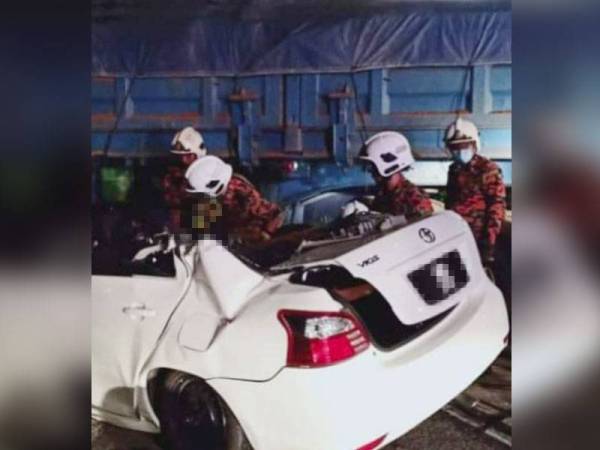 Anggota bomba membantu mengeluarkan mayat mangsa yang tersepit. - Foto JBPM