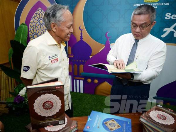 Menteri Kesihatan Malaysia, Datuk Seri Dr Adham Baba (kanan) melihat al-Quran sambil disaksikan oleh Timbalan Pengerusi Kumpulan Karangkraf, Datuk Muhammad Nasir Hamzah ketika majlis penyerahan al-Quran di Kementerian Kesihatan Malaysia. - FOTO SINAR HARIAN/ROSLI TALIB